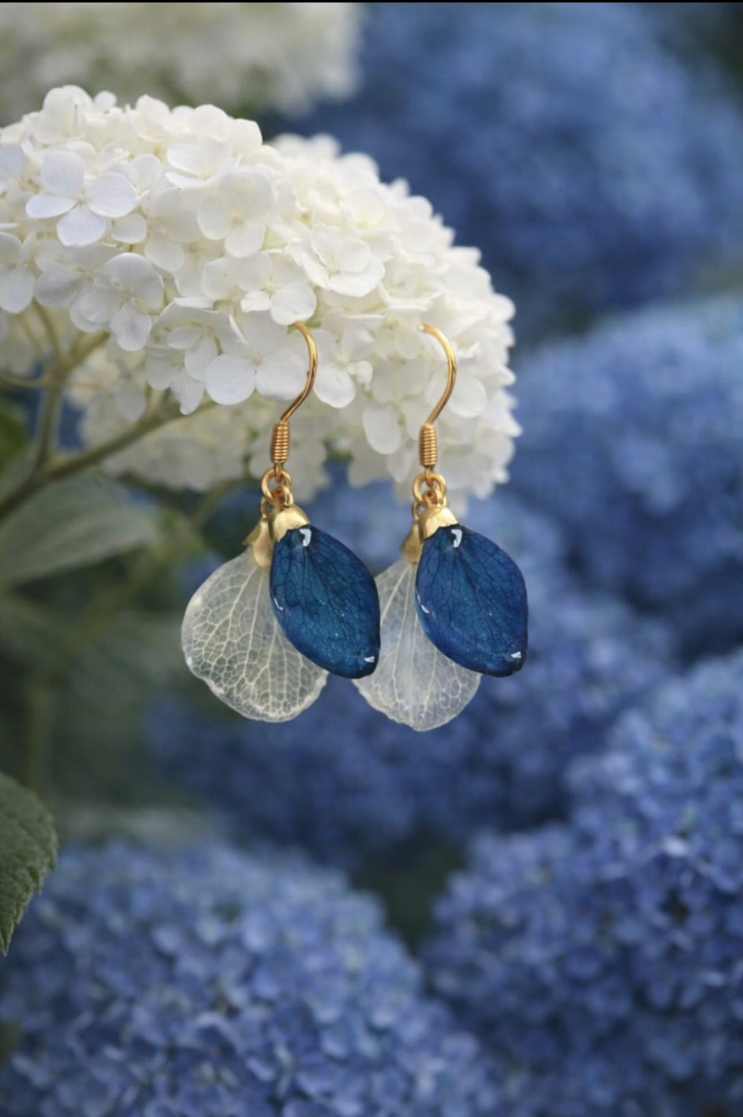 Dettaglio orecchini doppi con petali di ortensia bianco e blu in resina
